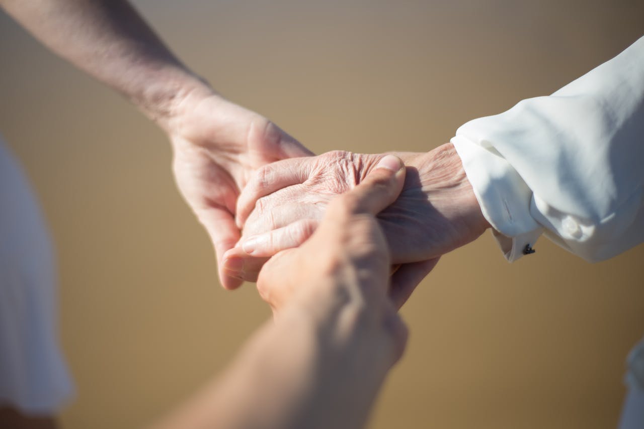 Gentle close-up of intergenerational hands holding, symbolizing connection and care.